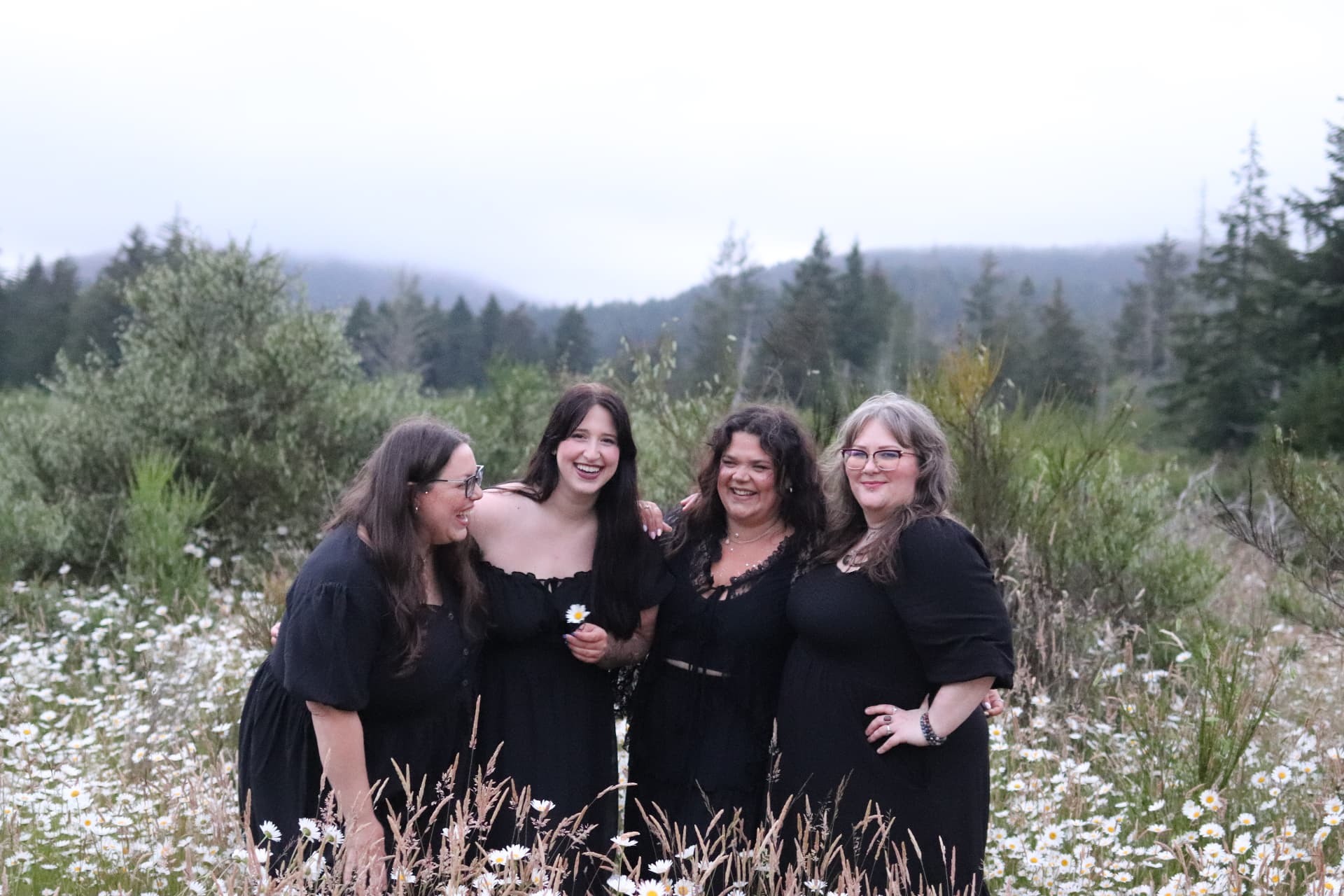 Women laughing together in a daisy field