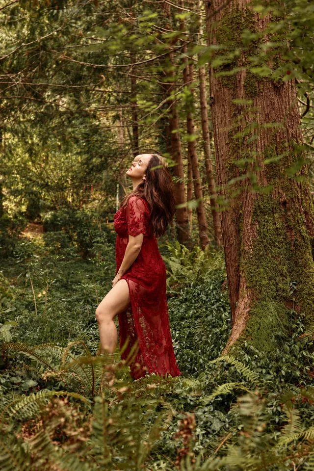 A woman in a red lace dress in the forest